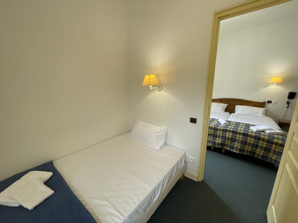 Chambre grande twin de l'hôtel saint Sébastien à Roquebillière contenant un lit simple et un lit double